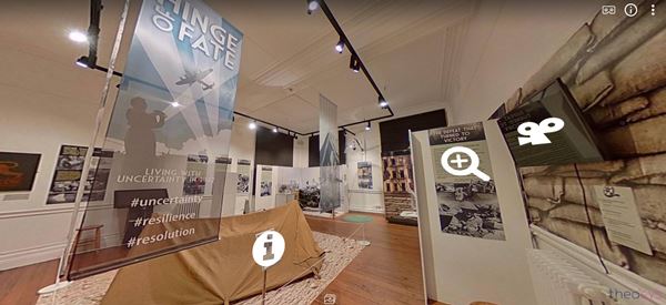 Screenshot from the Hinge of Fate exhibition virtual tour, showing a 2-man tent in the centre of the room, surrounded by other displays. The image is overlaid with icons indication further info is available in the form of pictures, videos or text.